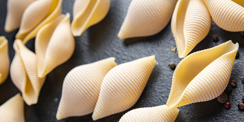 raw pasta Conchiglioni seashells mold form ingredient healthy meal food snack on the table copy space food background