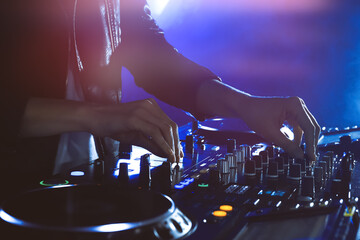 Fototapeta DJ creating music on modern console mixer in night club, closeup obraz