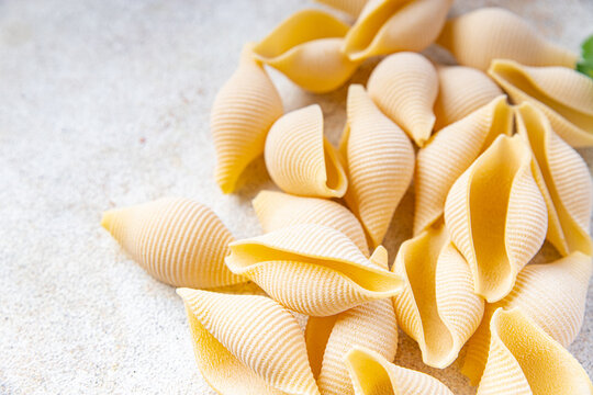 raw pasta Conchiglioni seashells mold form ingredient healthy meal food snack on the table copy space food background