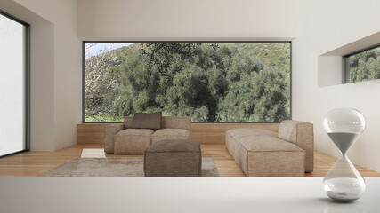 White table or shelf with crystal hourglass measuring the passing time over minimalist living room, architecture interior design, sofa, pouf, copy space background