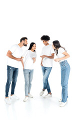 Naklejka premium full length view of smiling african american man chatting on smartphone near curious interracial friends on white.