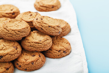 Oatmeal cookies on a blue background and a white napkin top view