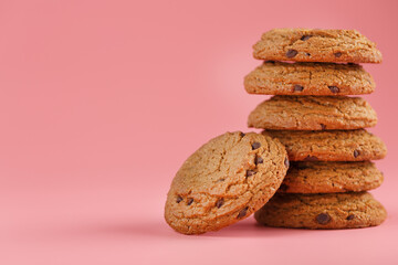 Oatmeal cookies stacked on a pink background.