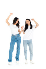 full length view of happy multiethnic women in t-shirts and jeans dancing on white.