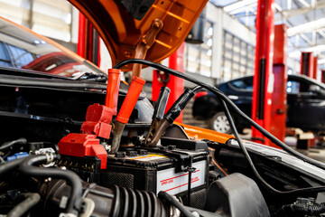 car repair concept. closeup charging car battery with electricity through jumper cables with...
