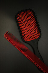 two red combs lie on a black background