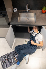 Man lying down fixing breakdown of sink