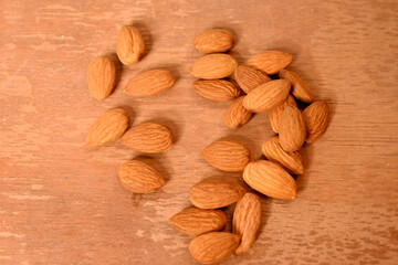closeup the bunch brown almond nuts over out of focus brown background.