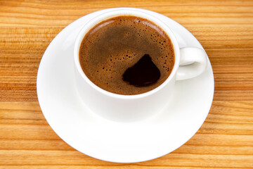Obraz na płótnie Canvas white cup of hot black coffee on a cork table