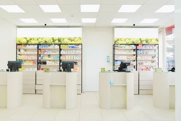 Zelfklevend Fotobehang Four empty without visitors clients staff cash point desks at pharmacy drugstore chemist`s store with white shelves full of medicines, jars with pills, remedy © InsideCreativeHouse