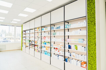 Empty pharmacy chemist`s store drugstore with white shelves full of medicines, jars with drugs, pills, remedy, antibiotics, vitamins. Copy space