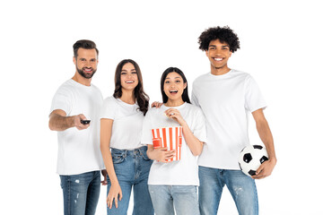 amazed asian woman eating popcorn while watching sport match with cheerful interracial friends isolated on white.