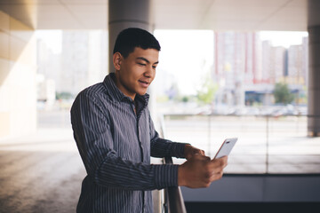 Young asian millennial guy use smartphone outdoor