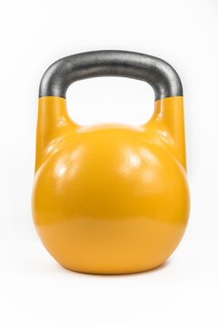 Classic heavy cast iron kettlebell, painted yellow against a white studio background.