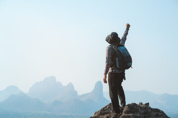 Success man hiker outstretched arms stand at cliff edge on mountain top.Concept of adventure travel