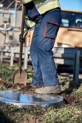 Worker with uniform maintaining street lawn.