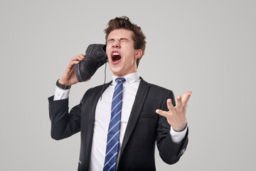 Comic businessman speaking on shoe like telephone