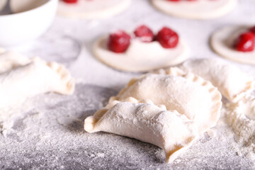 Fototapeta na wymiar dumplings with frozen cherries are prepared in the kitchen