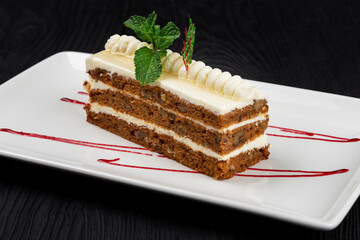 Chocolate cake decorated with mint leaves on black background