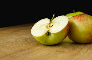 Fresh delicious apples on a wooden board and kitchen table. Healthy diet food fruits composition.