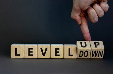 Level up or down symbol. Businessman turns cubes and changes concept words level down to level up....