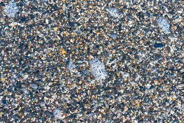 sea beach of small multi-colored pebbles as a natural background