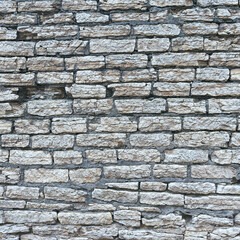 old stone wall made of weathered bricks as background