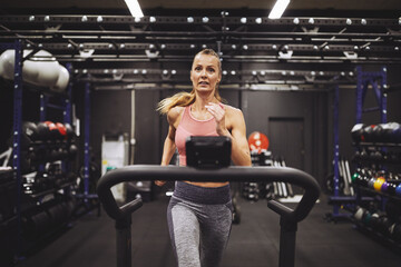 Mature woman working out on a treadmill at the gym