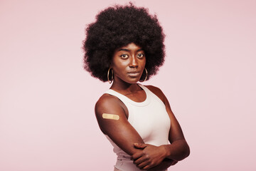 Confident African woman with a vaccination bandage