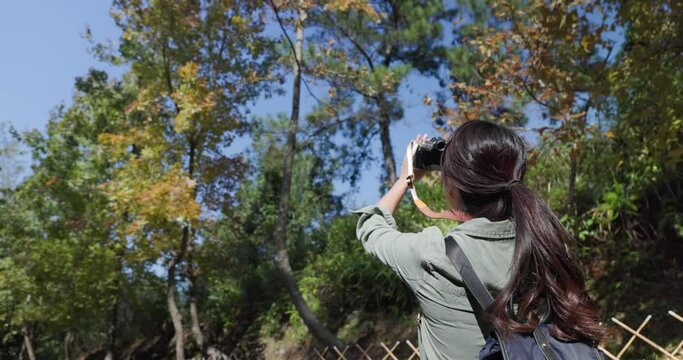 Woman take photo on camera while hiking