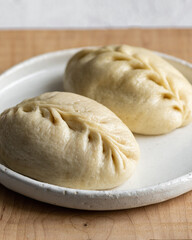 Traditional Korean steamed buns, pyanse or pigodi, on white wooden background, selective focus