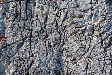 Beautiful texture of natural gray and yellow granite stone surface with cracks in the photo