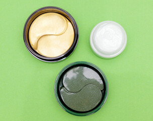 Hydrogel eye masks and cream to moisturize the skin of the face. Anti-aging natural cosmetics with a tightening, moisturizing and anti-stress effect. eye patches in jar, flat lay