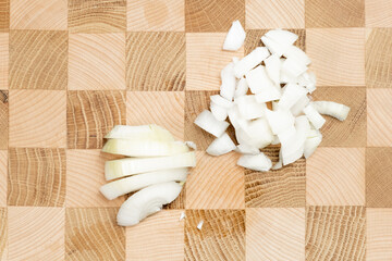 chopped onion on a wooden board. Wooden board in the form of a chessboard. Preparation for cooking. Top view.