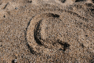 Fototapeta na wymiar English alphabet. Sand on the beach. The letter c
