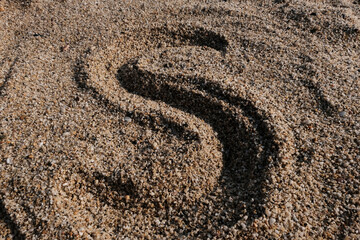 Fototapeta na wymiar English alphabet. Sand on the beach. The letter S