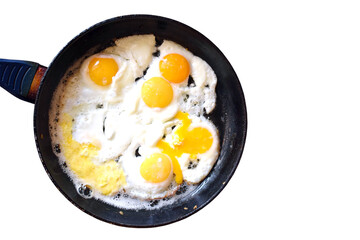 Fried eggs in a frying pan on a gas stove, top view
