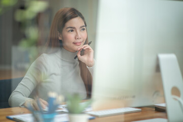 Portrait of a serious businesswoman using laptop in office,doing math finance report on wooden desk, tax, accounting, statistics and analytical research concept 