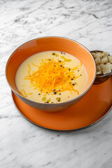 Cream cheese soup. First course in a festive plate on a marble background. Restaurant banquet menu.