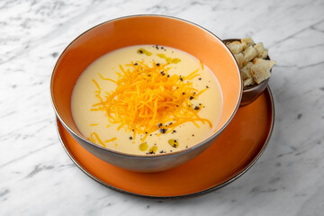 Cream cheese soup. First course in a festive plate on a marble background. Restaurant banquet menu.