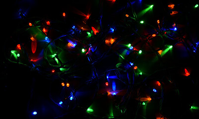 Electric garland on a wooden background, bright bulbs, night