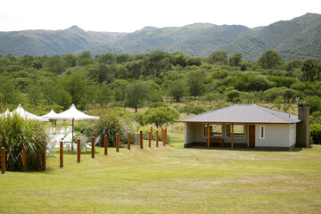 Swimming pool. Recreation, relaxation, vacations, tourism, peace. Nature and mountains. Landscape of Córdoba, Argentine. Umbrellas and lounge chairs. Summer.