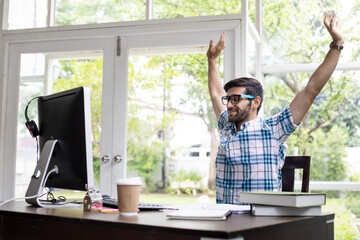 Young man stretching while working at home.