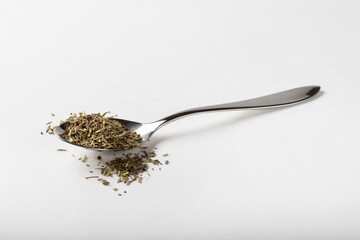 Seasoning dried rosemary on a white background in a spoon for insulation