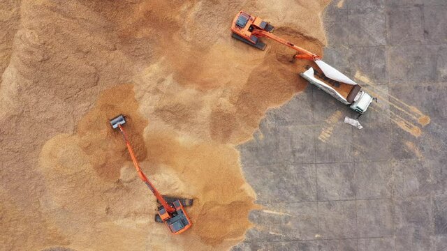 Construction site, Aerial top view road roller and loader excavator tractor and soil grade car earthmoving at work, Heavy equipment is grading the land, moving and flattening out red clay soil.