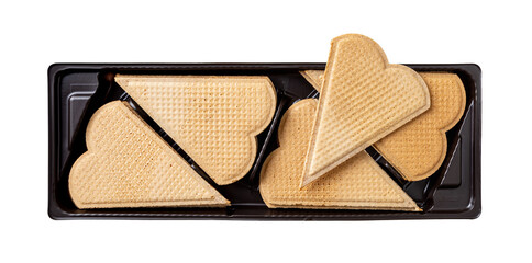 Heart shaped wafers for garnishing in a black plastic container isolated on a white background. Thin flat waffle biscuits for ice cream decoration. Sweet baked pastry for Valentine day food design.