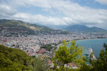 Fototapeta na wymiar Sea in Turkey, Alanya through trees. Lighthouse in the background. View from above.