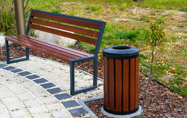 garbage can by a park bench