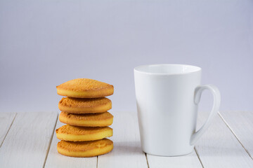 Cookies and white cup on a white wooden table