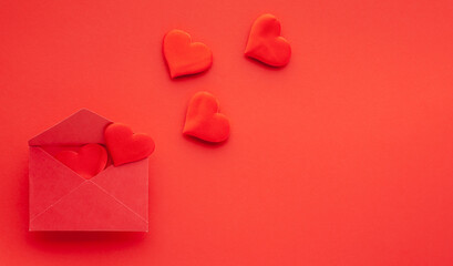 Valentine's day or Wedding romantic concept. Red hearts and envelope on red background. Top view, copy space.